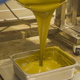 Dubai Pistachio paste being poured into a pan for mixing into dubai bars
