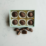 Box of chocolates with some on a marble surface