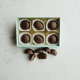 Box of chocolates with some on a marble surface