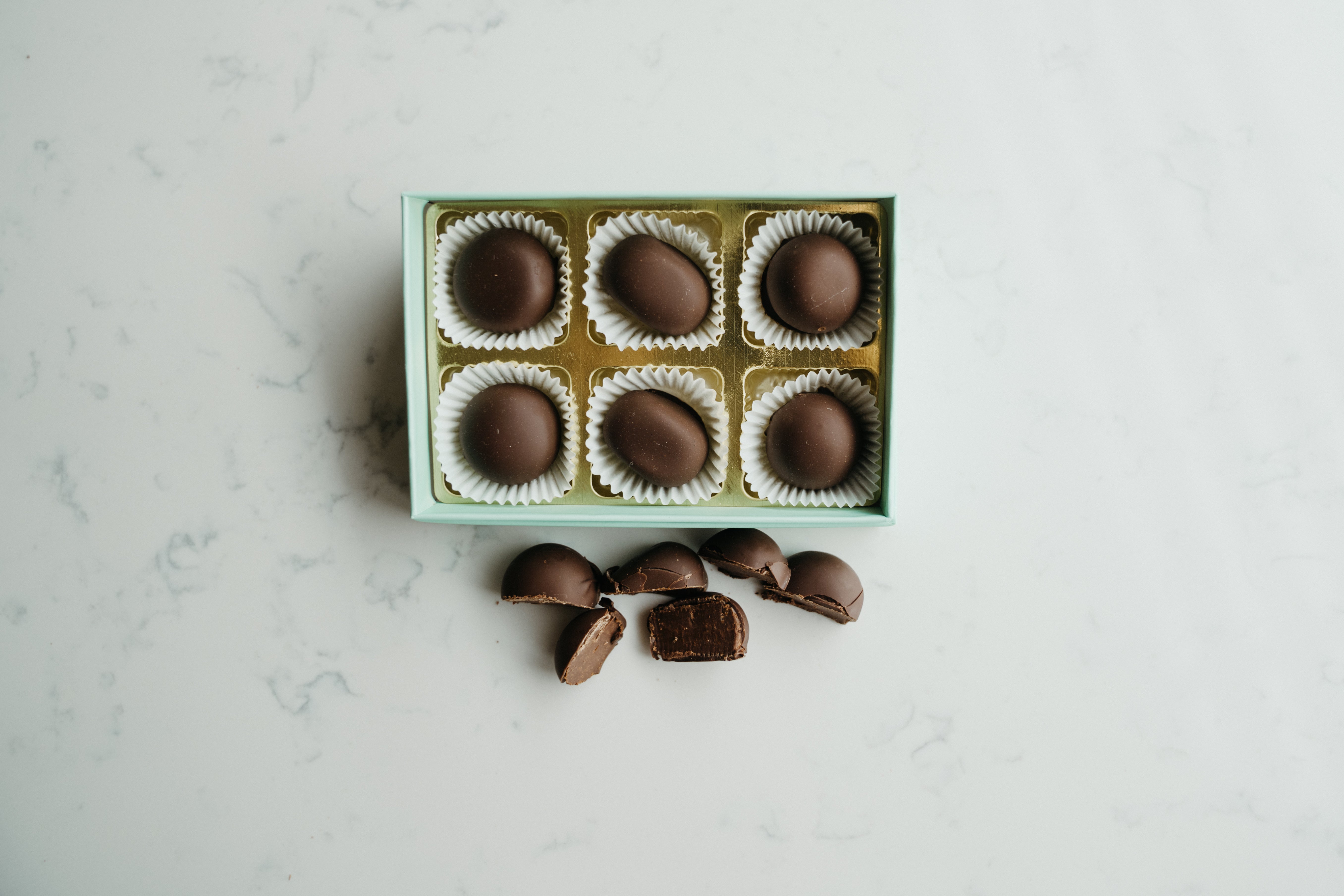 Box of chocolates with some on a marble surface